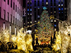 A Christmas tree covered in lights with a star on top in New York