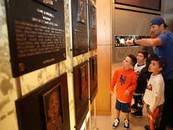 A man and some children looking at plaques in a museum
